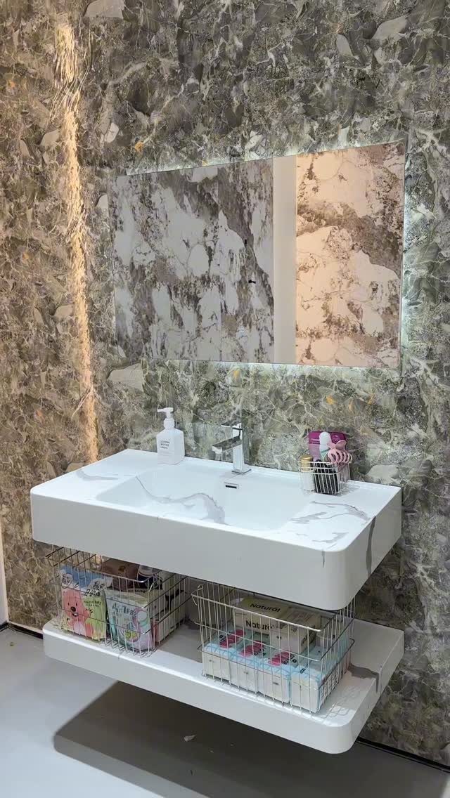 14 Bathroom Small Space Storage Ideas That Actually Fit 5 White floating bathroom vanity with wire storage baskets containing toiletries against a marble wall.