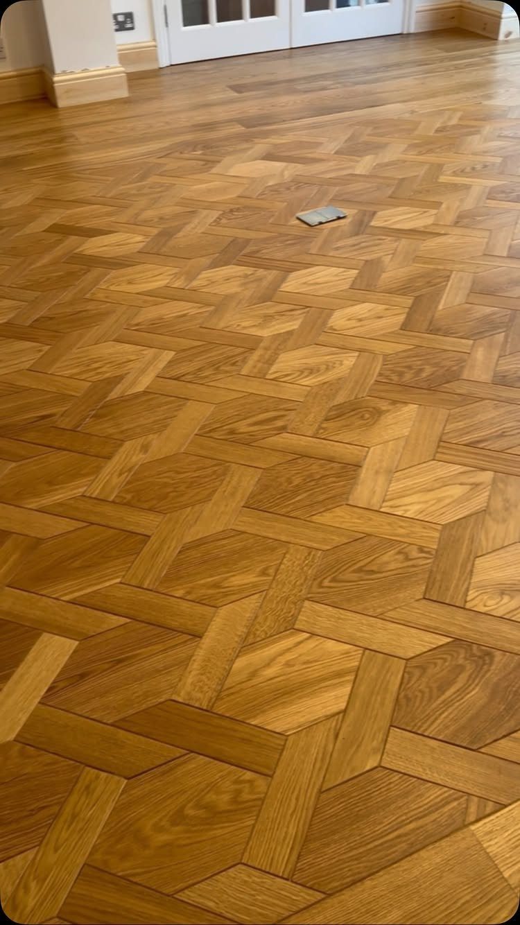 Custom geometric hardwood floor with interlocking light brown wood planks in a unique pattern.
