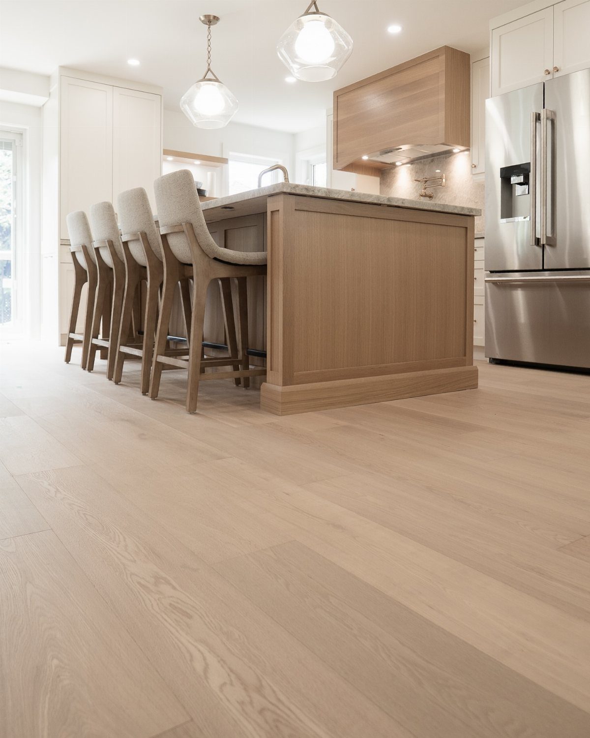 Light white oak hardwood floors in a bright, modern kitchen with a wooden island.