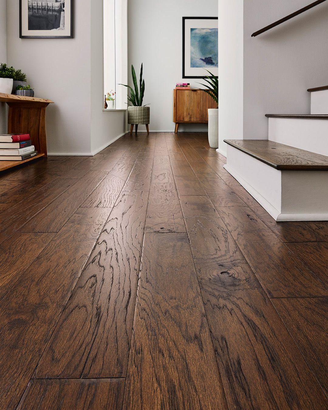 Dark brown hardwood floor planks with a soft sheen in a modern hallway.