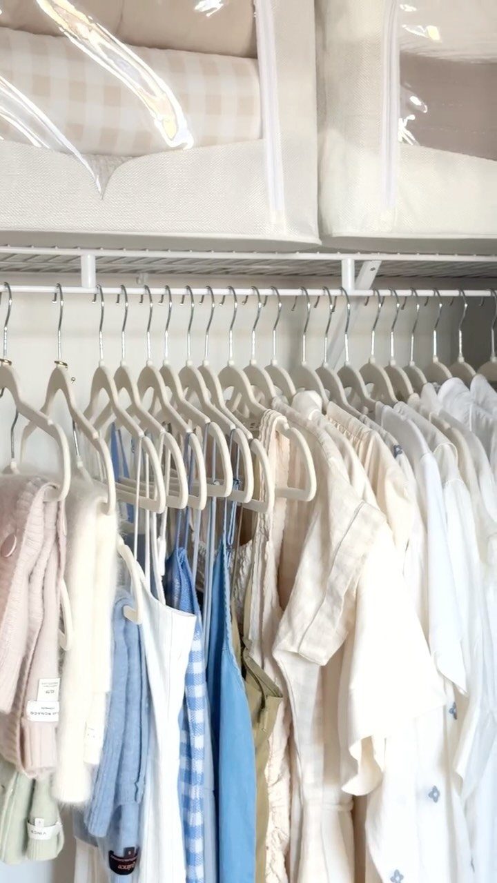 6 Closet Organization for Dresses Ideas That Save Space and Time 2 White velvet hangers holding light-colored clothing on a white closet rod with storage bins above.