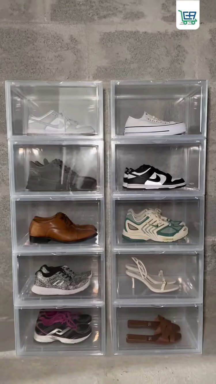 Two stacks of clear plastic bins containing various pairs of shoes against a grey wall.