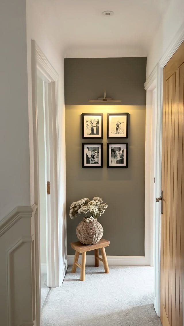 Four black framed monochrome photos arranged in a grid on a green accent wall.
