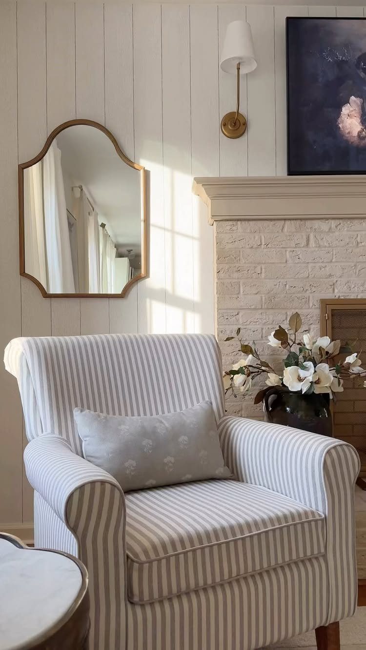 Striped armchair positioned in front of a white vertical wood paneling accent wall.