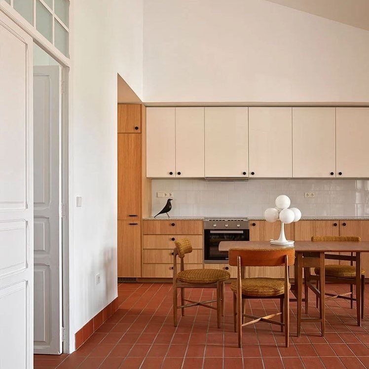 11 Kitchen Flooring Trends for 2026 That Actually Hold Up 11 Terracotta tile flooring in a modern kitchen with wooden cabinets and a dining area.