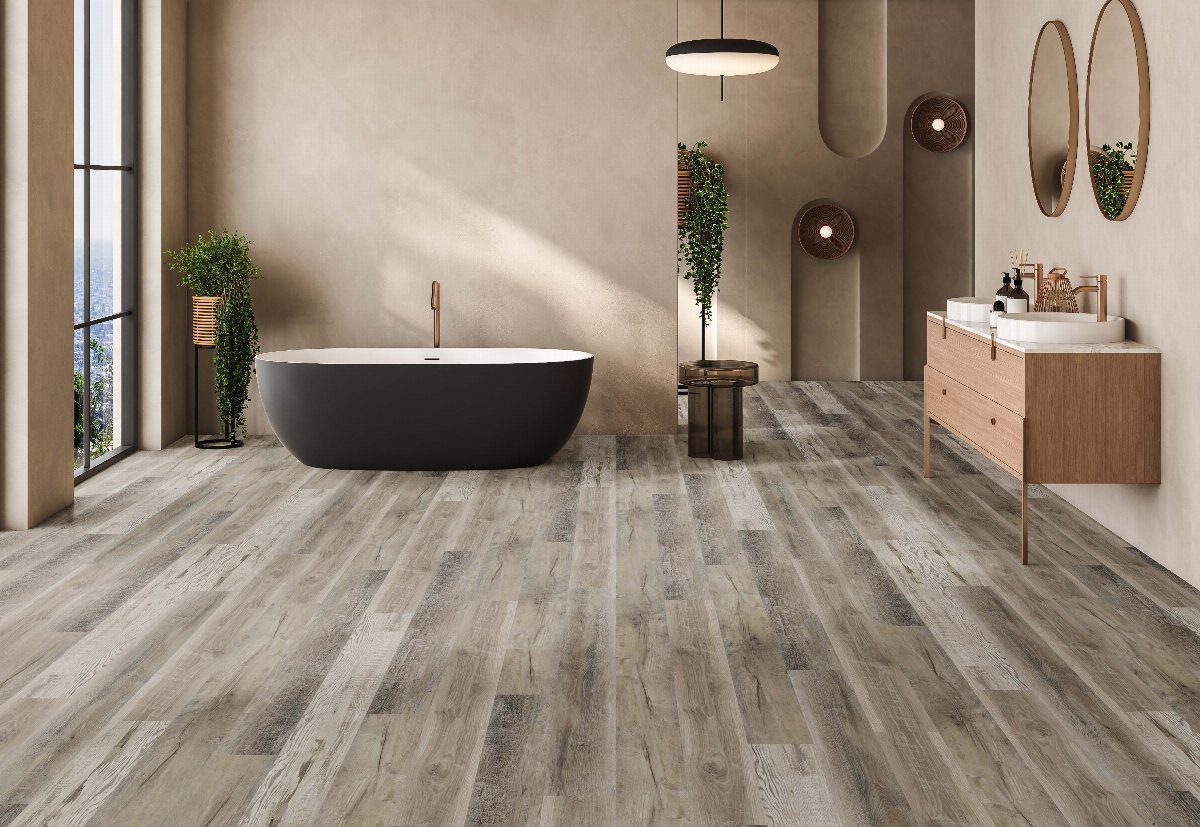 Grey wood-look luxury vinyl flooring in a modern bathroom with a black bathtub.
