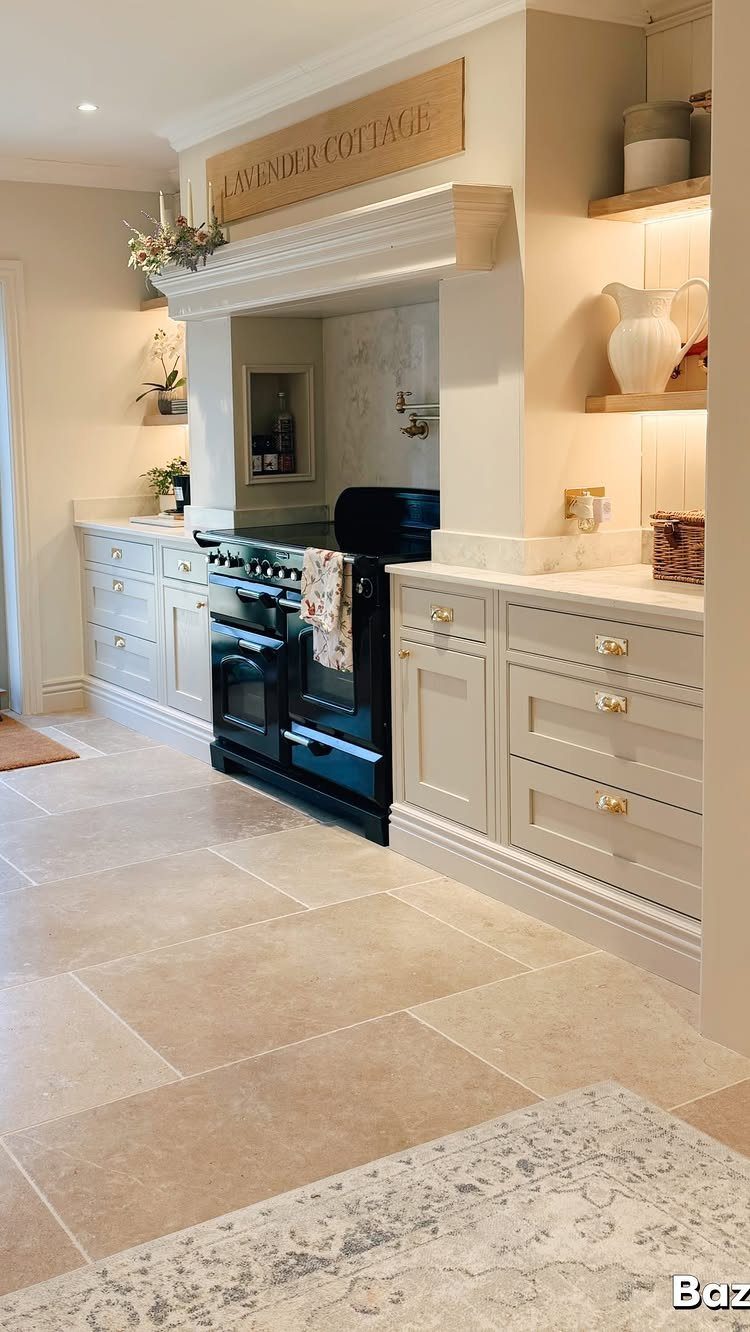 Light beige stone-effect tiles covering a modern farmhouse kitchen floor near cream cabinetry.