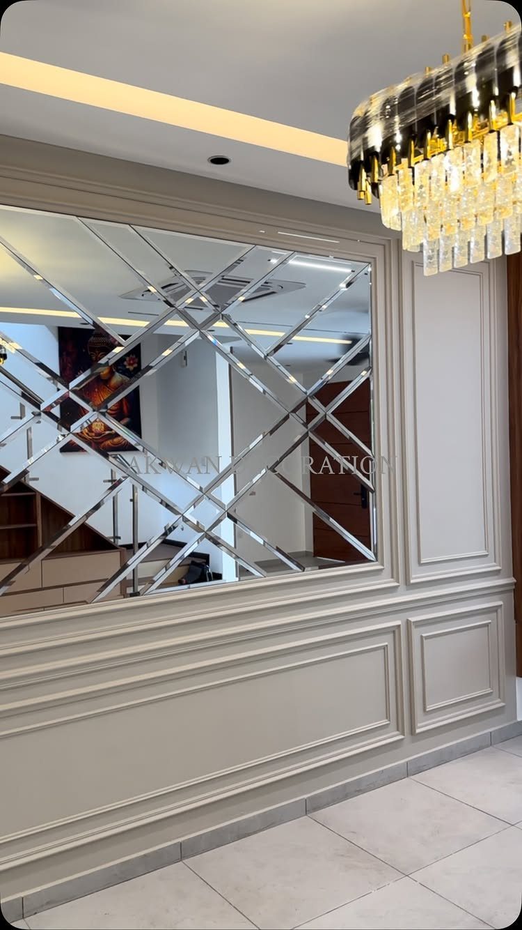 Grey wainscoting wall with decorative molding and a large diamond-patterned mirror inset.