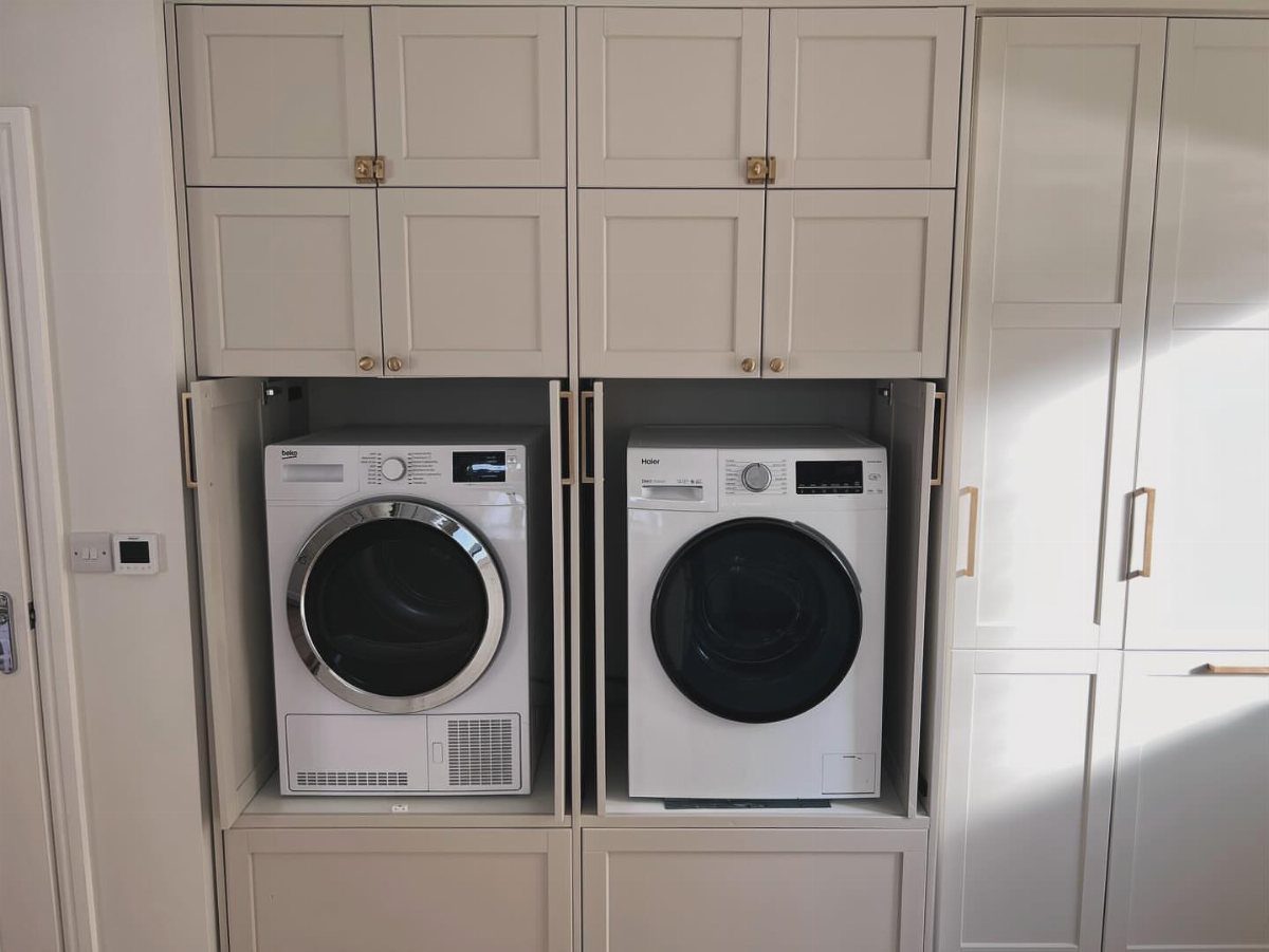 10 Small Laundry Closet Ideas That Actually Fit in a Hallway 9 White washing machine and dryer installed inside built-in beige laundry room cabinetry.