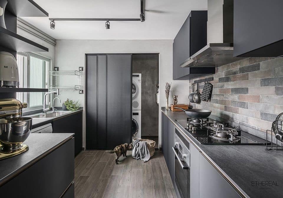 10 Small Laundry Closet Ideas That Actually Fit in a Hallway 6 Modern kitchen with dark cabinets and large grey sliding doors covering a laundry area.