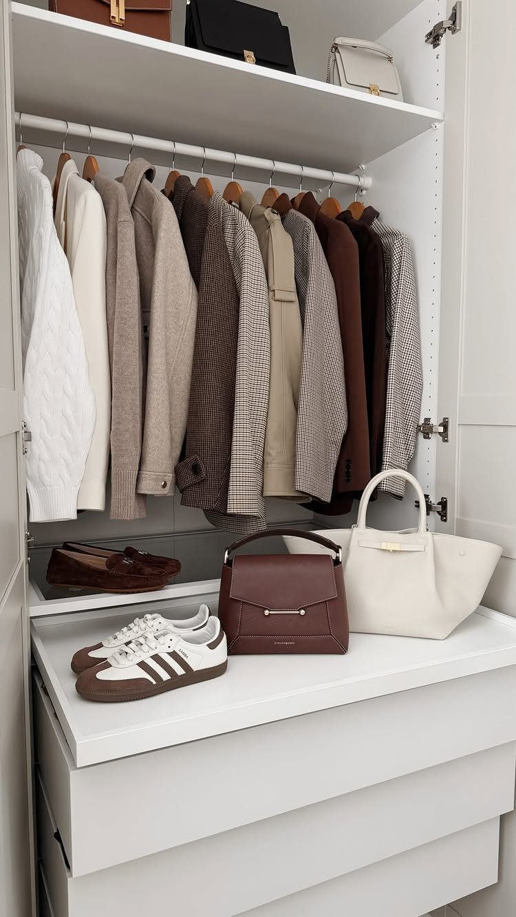8 Storage Closet Organization Ideas for Tighter Spaces 2026 3 Neutral colored jackets hanging in a white closet with handbags and shoes on the shelf below.