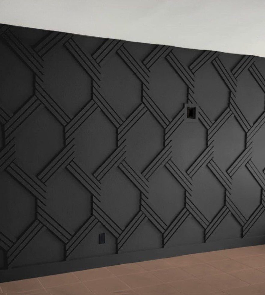 Black wall with a raised 3D geometric pattern of intersecting lines forming hexagonal shapes.