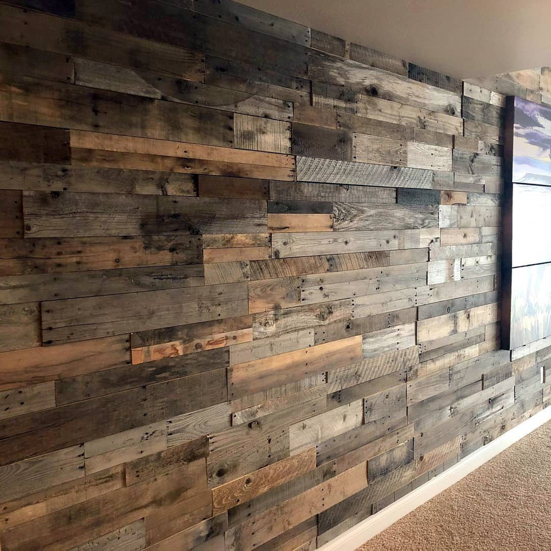 Reclaimed wood panels in various natural tones covering a large interior feature wall.