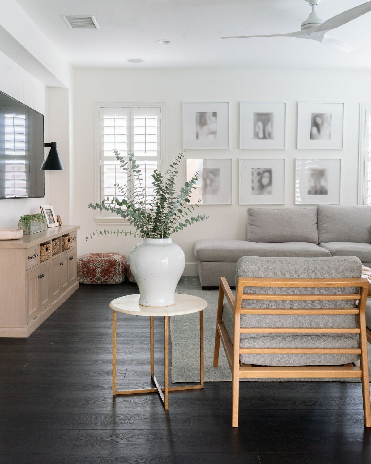 Dark charcoal wood flooring in a bright, modern living room with grey furniture.