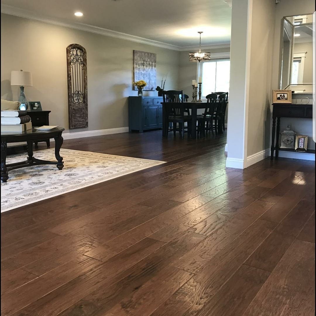 Dark brown hardwood flooring stretching through a modern living and dining room area.